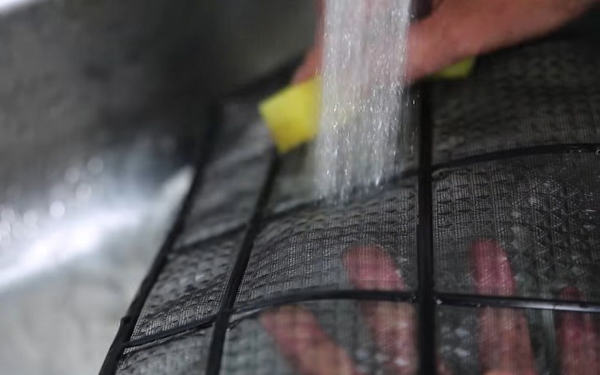 Sử dụng miếng rửa bát để loại bỏ bụi bẩn bám trên lưới lọc